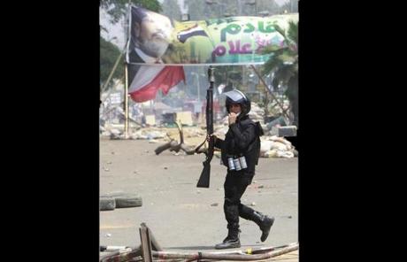 A riot police officer walked at the entrance of Cairo University and Nahdet Misr Square.
